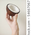 Hand holding sliced coconut 54667067