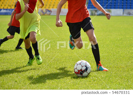 Young football players play football at  stadium Young football players play football at  stadium 54670331