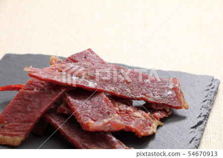 Beef jerky on a slate plate. Beef jerky on a slate plate. 54670913
