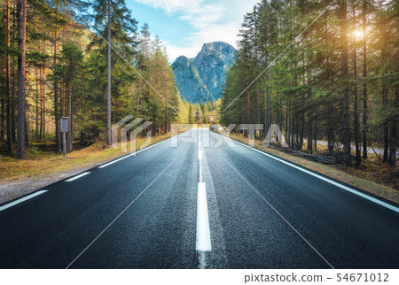 Road in summer forest at sunset in Italy. Mountain 54671012