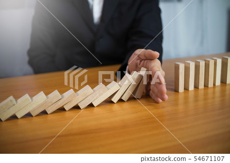 Businessman hand stops wood block continuous. Businessman hand stops wood block continuous. 54671107