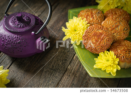 Mooncakes, teapot, yellow chrysanthemum flowers. 54673508