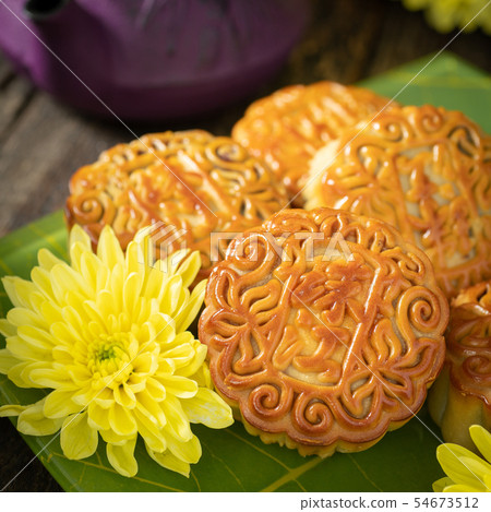Mooncakes, teapot, yellow chrysanthemum flowers. 54673512