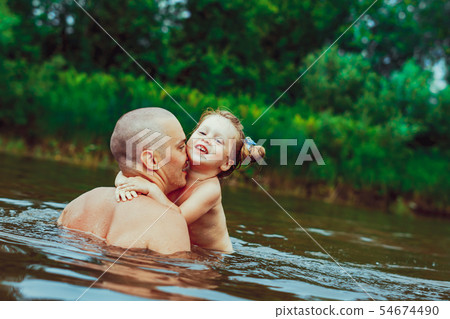 Dad and child bathe in the river 54674490