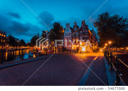 Amsterdam illuminated bridge with typical dutch houses in evening blue hour lights, Holland Amsterdam illuminated bridge with typical dutch houses in evening blue hour lights, Holland 54677080