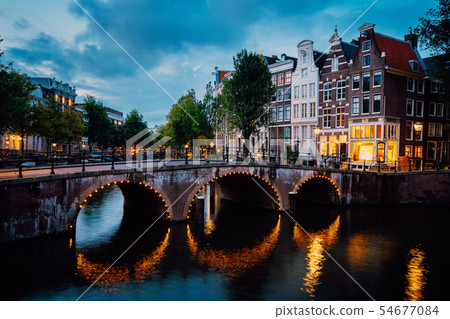 Night city view of Amsterdam canal Herengracht, typical dutch houses in evening dusk lights, Holland Night city view of Amsterdam canal Herengracht, typical dutch houses in evening dusk lights, Holland 54677084