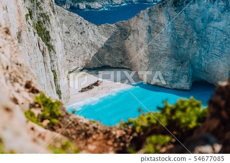 Famous shipwreck on Navagio beach with turquoise blue sea water surrounded by huge white cliffs 54677085