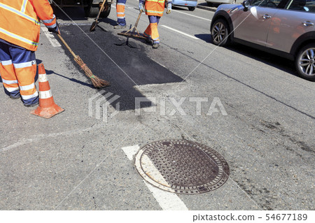 The working team smoothes hot asphalt 54677189