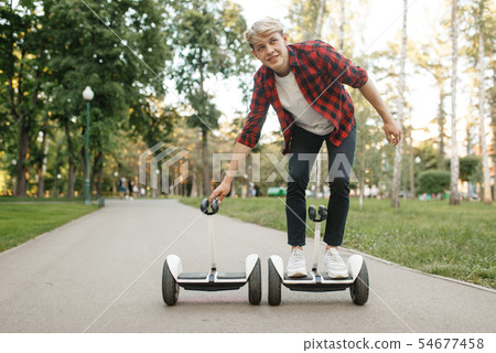 Young man riding on gyro board in summer park 54677458
