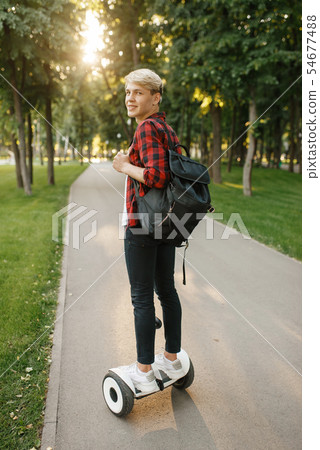 Young man with backpack riding on mini gyro board 54677488