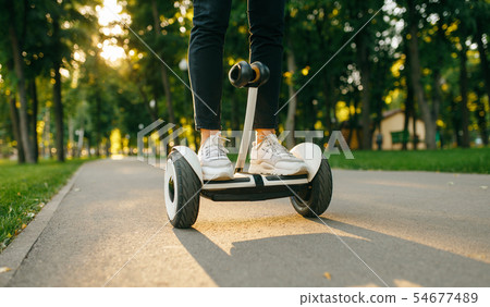 Young male person riding on gyroboard in park 54677489