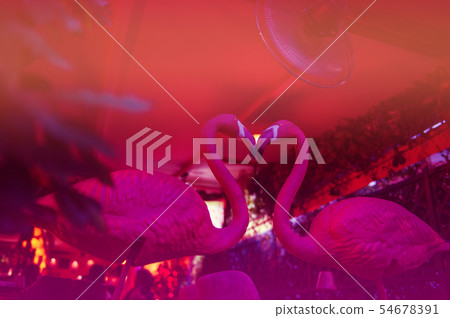 A pink flamingo ceramic facing each other to form a heart shape A pink flamingo ceramic facing each other to form a heart shape 54678391