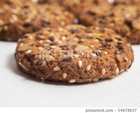 Macro photo of brown dietary low-calorie fitness cereal biscuits with sprinkling closeup on white Macro photo of brown dietary low-calorie fitness cereal biscuits with sprinkling closeup on white 54678637
