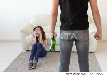 domestic violence, alcoholic and abuse concept - drunk man with bottle abusing his wife lying on the domestic violence, alcoholic and abuse concept - drunk man with bottle abusing his wife lying on the 54679565