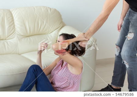 domestic violence, victim and abuse concept - cruel aggressive man grabbing woman lying on the floor 54679586