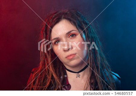 Youth, hairstyle and modern concept - young woman with dreadlocks over the red and blue light 54680557
