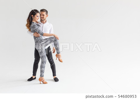 Social dance, bachata, kizomba, zouk, tango concept - Man hugs woman while dancing over white 54680953
