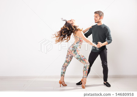 Social dance, kizomba, tango, salsa, people concept - beautiful couple dancing bachata on white Social dance, kizomba, tango, salsa, people concept - beautiful couple dancing bachata on white 54680958