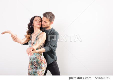 Skillful dancers performing in the white background with copy space. Sensual couple performing an Skillful dancers performing in the white background with copy space. Sensual couple performing an 54680959