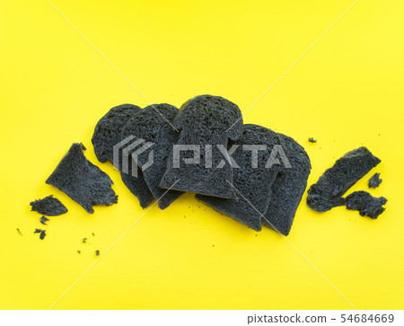 Organic bio charcoal bread on yellow background 54684669