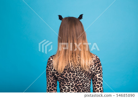 The evil woman with a waist bat on the head. Fancy dress for Halloween on blue background, back view 54685890