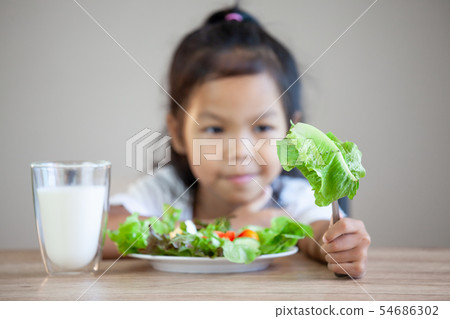 Cute asian child girl eating healthy vegetables Cute asian child girl eating healthy vegetables 54686302