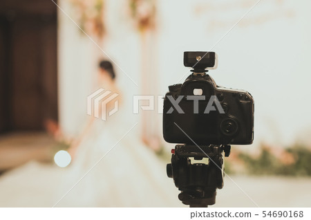 Close-up of professional DSLR digitak camera attached with tripod in wedding ceremony 54690168