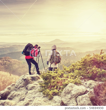 Man and girlfriend shooting sunset on the top 54694930