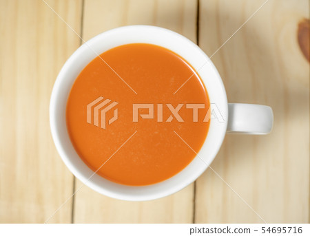 Hot milk tea in a white cup on wooden 54695716