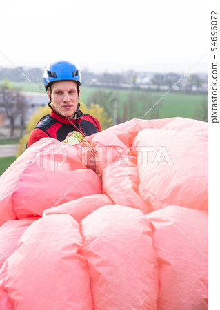 Paraglider landed after jump at bright spring day Paraglider landed after jump at bright spring day 54696072