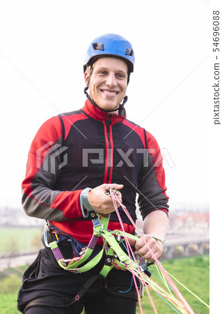 Landed parachutist in red uniform smiles in camera Landed parachutist in red uniform smiles in camera 54696088