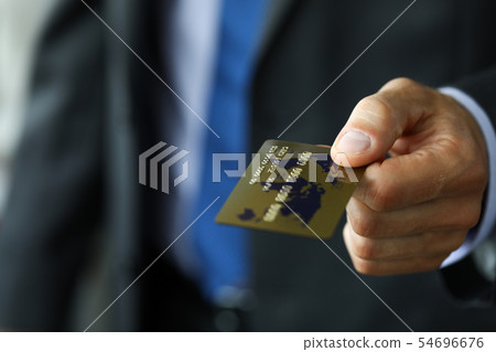 Man in suit and tie offering banking card to pay for service Man in suit and tie offering banking card to pay for service 54696676