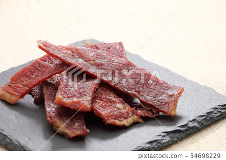 Beef jerky on a slate plate. 54698229