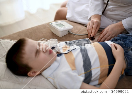 The doctor measures the pressure of a squinted boy 54699031