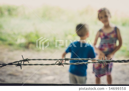 Kids behind berbed wire 54699358
