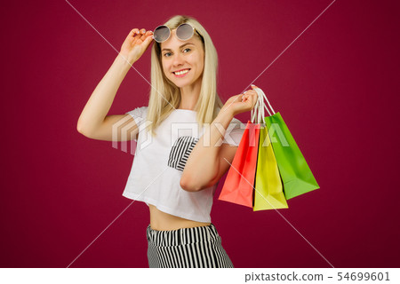 Happy girl in sunglasses holds shopping bags 54699601