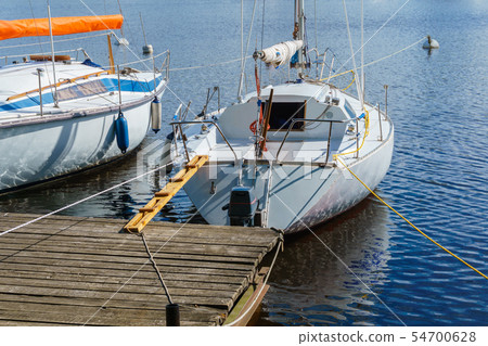 small yachts moored at a wooden pier small yachts moored at a wooden pier 54700628