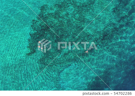 Father and son snorkels through tropical water 54702286