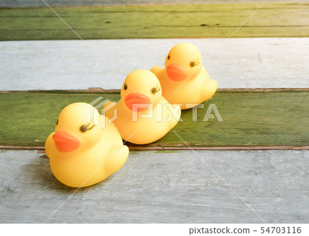 Rubber yellow ducks toy on wooden table background Rubber yellow ducks toy on wooden table background 54703116
