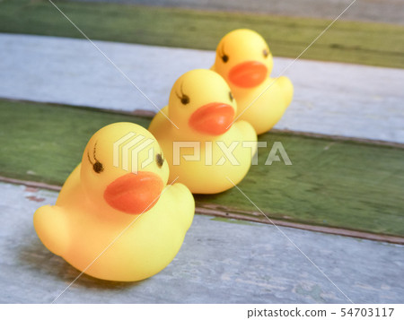 Rubber yellow ducks toy on wooden table background Rubber yellow ducks toy on wooden table background 54703117