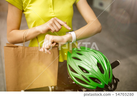 Young woman as a courier delivering package using gadgets Young woman as a courier delivering package using gadgets 54703280