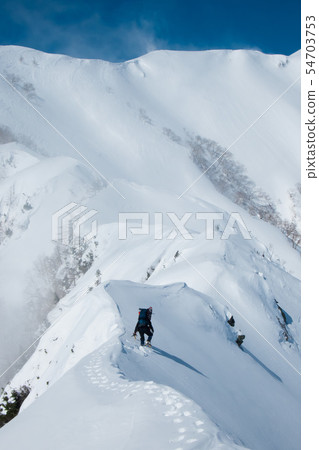 Climbing a snowy mountain Climbing a snowy mountain 54703753
