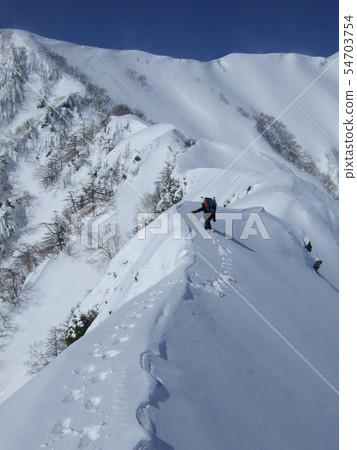 Climbing a snowy mountain 54703754