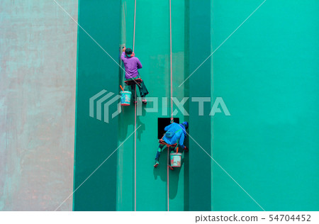 Painters hanging outside of a high building Painters hanging outside of a high building 54704452