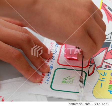 Hand pushing stamp in stamp rally 54716559