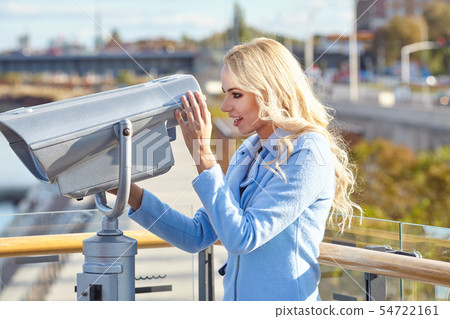Cheerful young tourist using telescope tower Cheerful young tourist using telescope tower 54722161