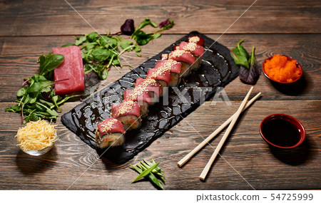 Serving sushi rolls and other traditional japanese and asian food on a table 54725999