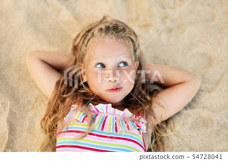 Beautiful little blonde girl relax on the beach wonder about summer holiday Beautiful little blonde girl relax on the beach wonder about summer holiday 54728041