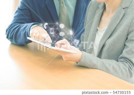 Two confident businesspeople using a digital 54730155