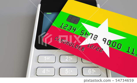Bank card featuring flag of Myanmar and POS payment terminal. Myanma banking system or retail 54734659